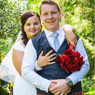 bride holding arms over grooms shoulders at Flaxmere Gardens Wedding Venue in Hawarden in Canterbury