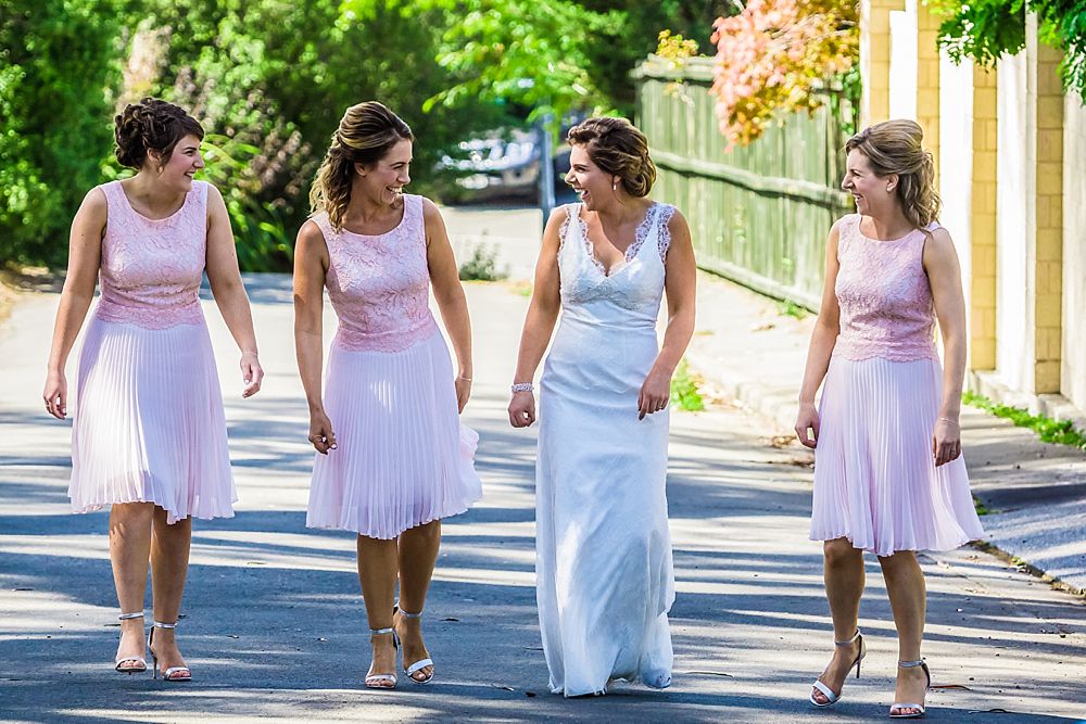 Bridesmaids walking down the street outside bride's home in Christchurch