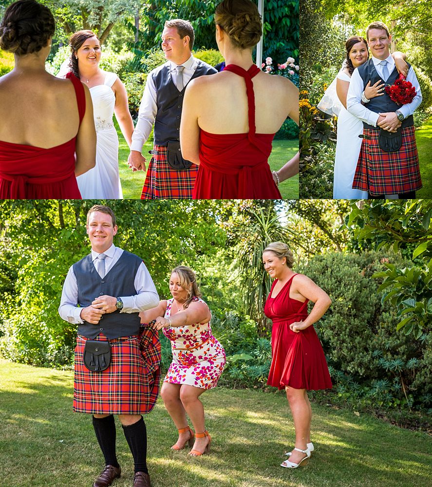 Groom in a red and black kilt with his sisters at wedding venue