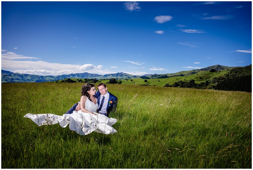 Mt Vernon Lodge Wedding-Bride and groom sitting in the green grass-Akaroa
