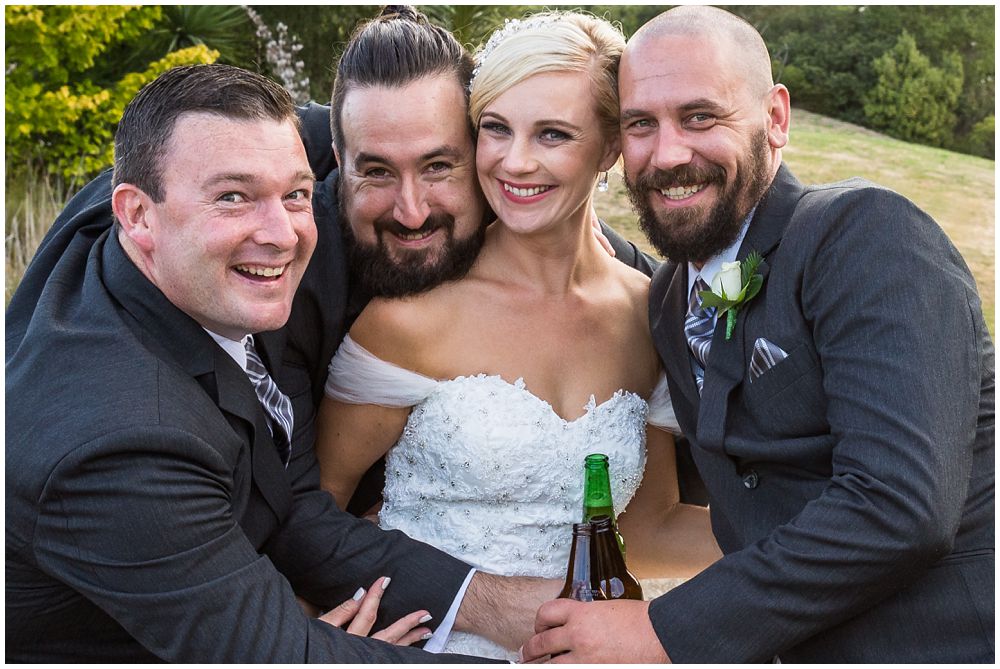 photo of photographs bride surrounded by the groomsmen posing for a fun one